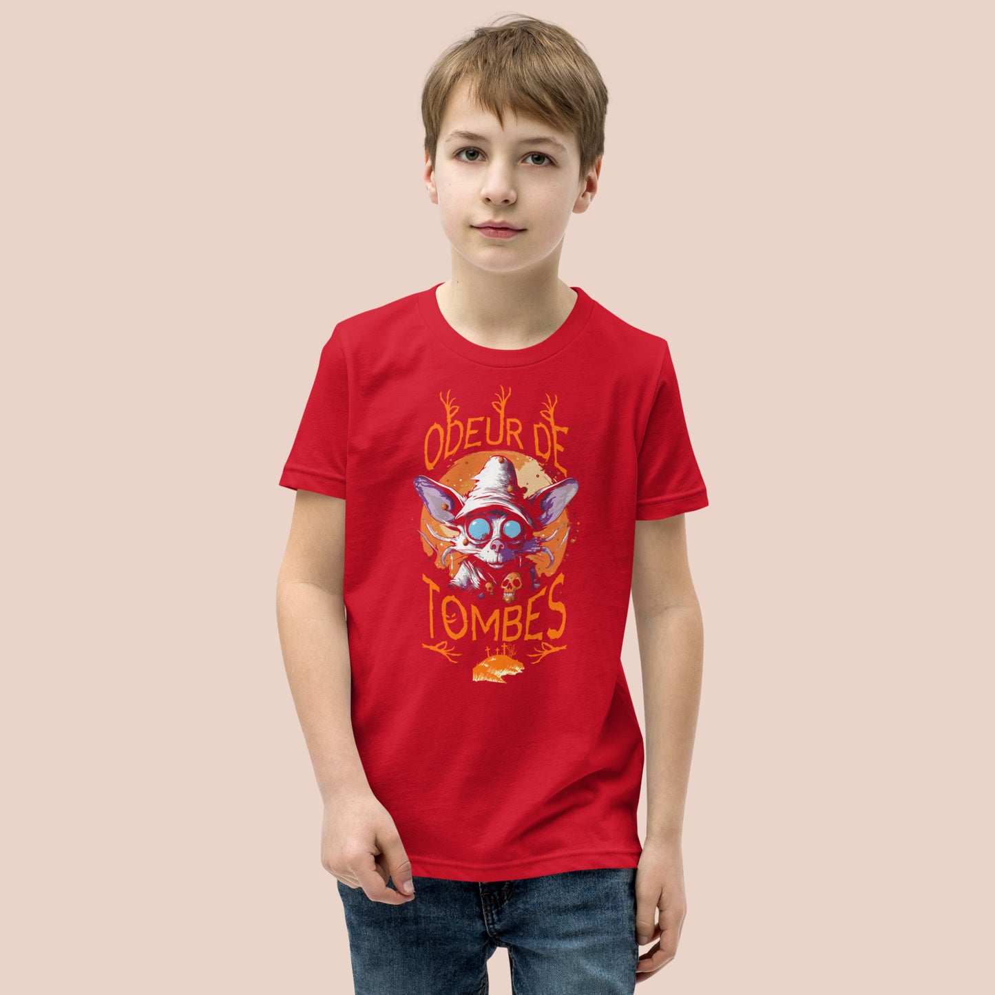 Garçcon sérieux portant un t-shirt rouge illustré d'un monstre et inscrit Odeur de tombes. Vue du devant.