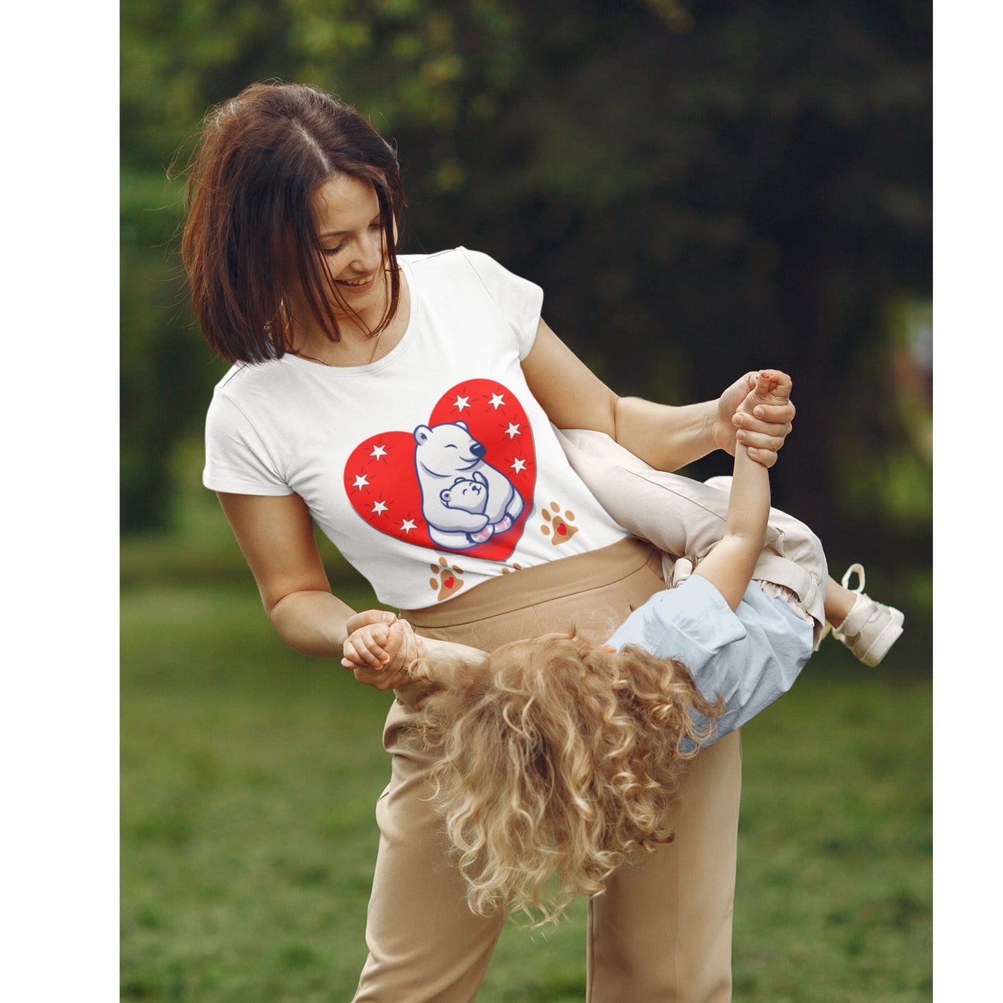 Maman souriante portant un t-shirt blanc motif ours polaire en jouant avec son enfant