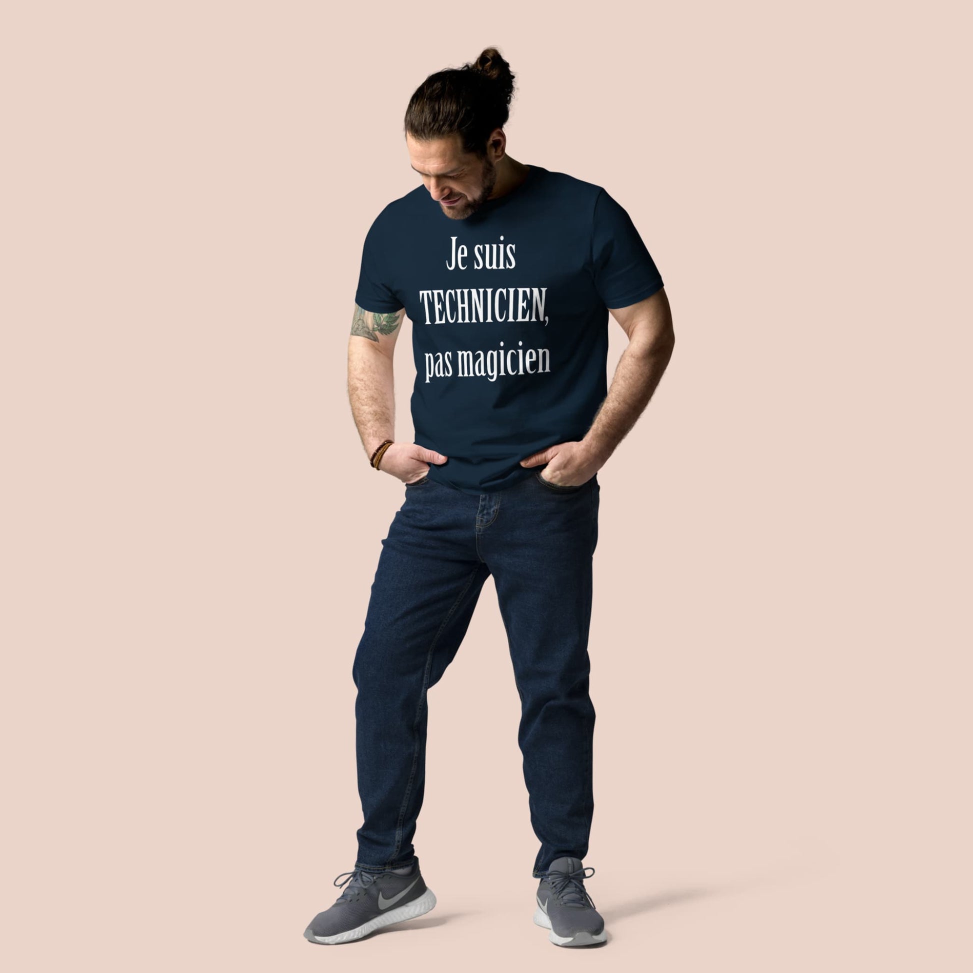 Homme portant un t-shirt bleu marine en coton bio avec message blanc « Je suis technicien, pas magicien » – Artic60