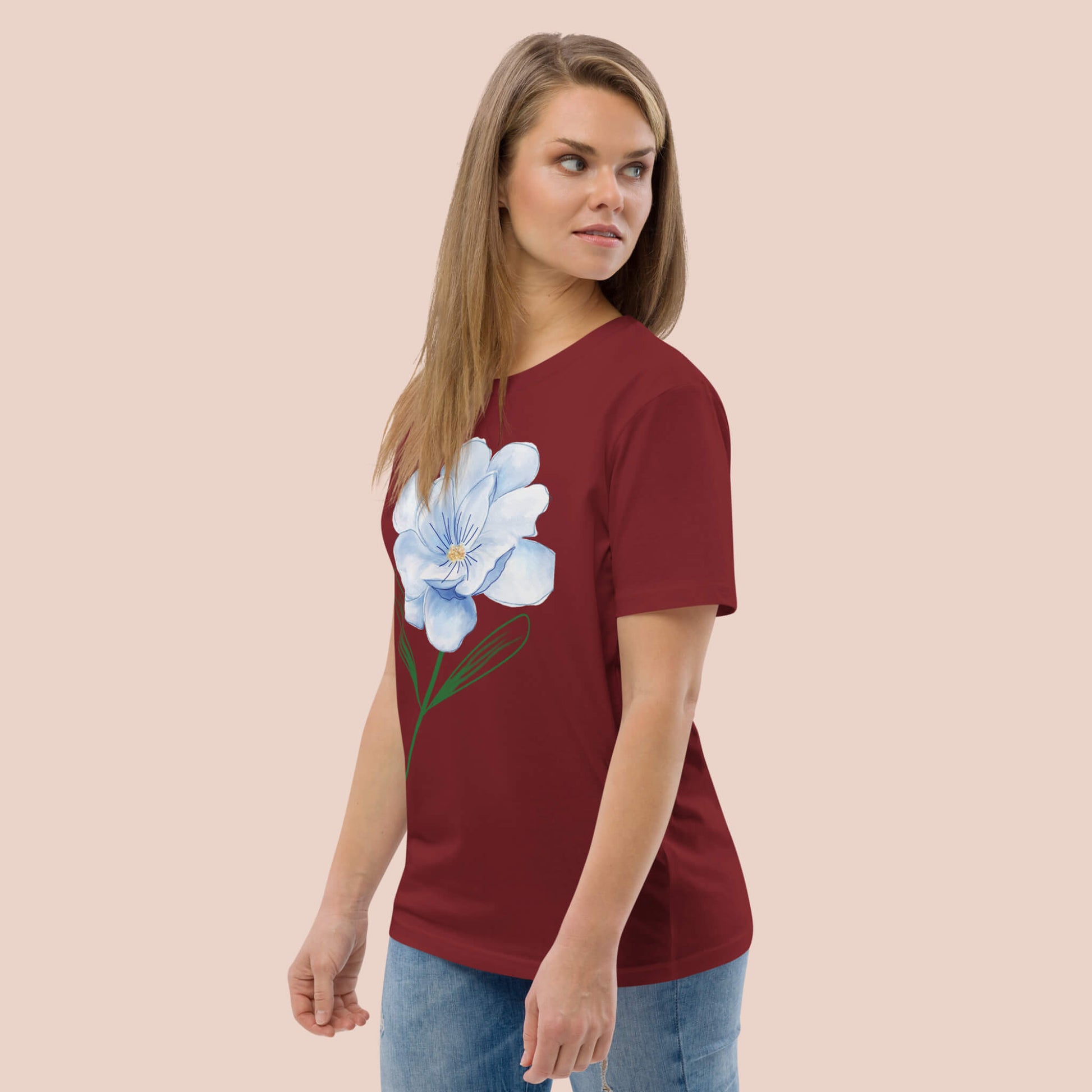 Femme de profil portant un t-shirt bourgogne en coton bio avec une fleur bleue – Artic60