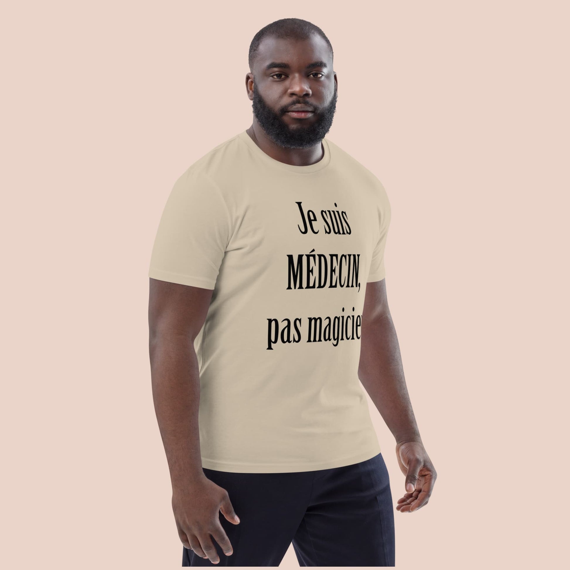 Homme portant un t-shirt beige désert avec texte noir « Je suis médecin, pas magicien » – Artic60