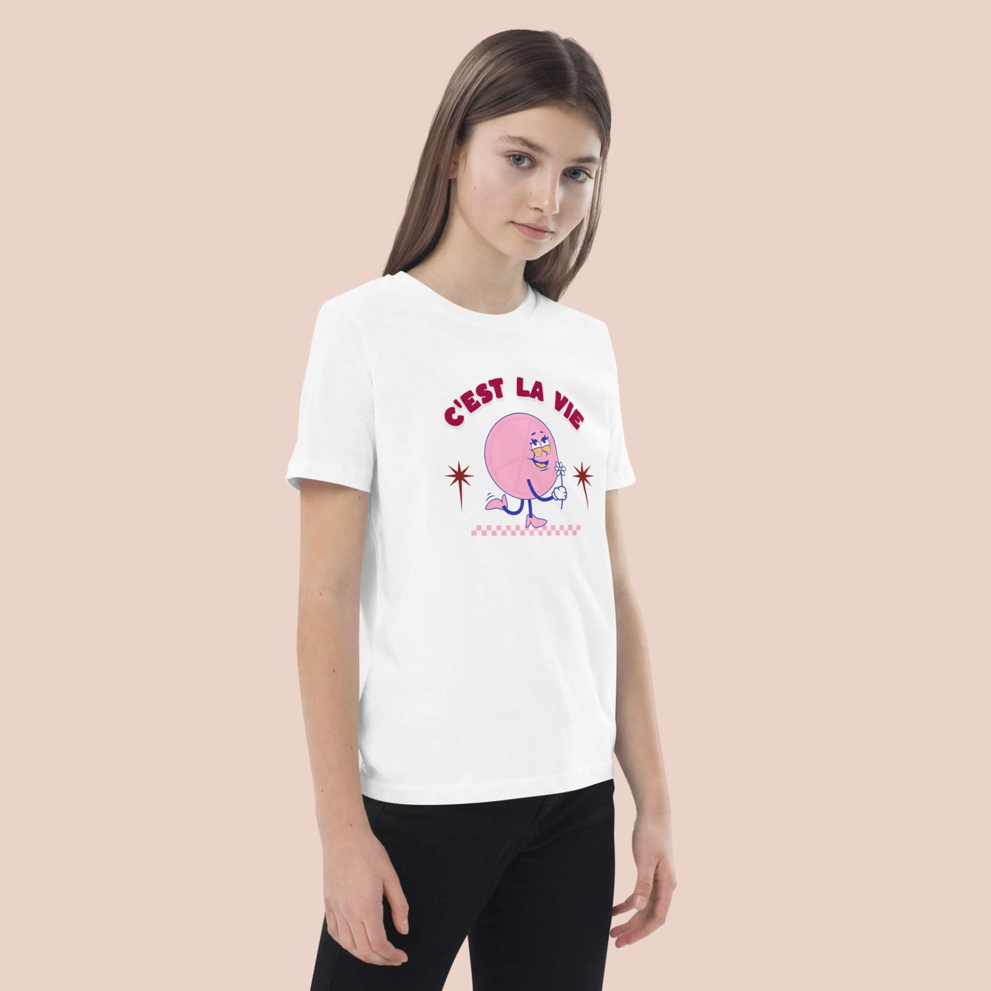 Fille portant un t-shirt blanc en coton bio avec un personnage rose et l’expression « C’est la vie » – Artic60