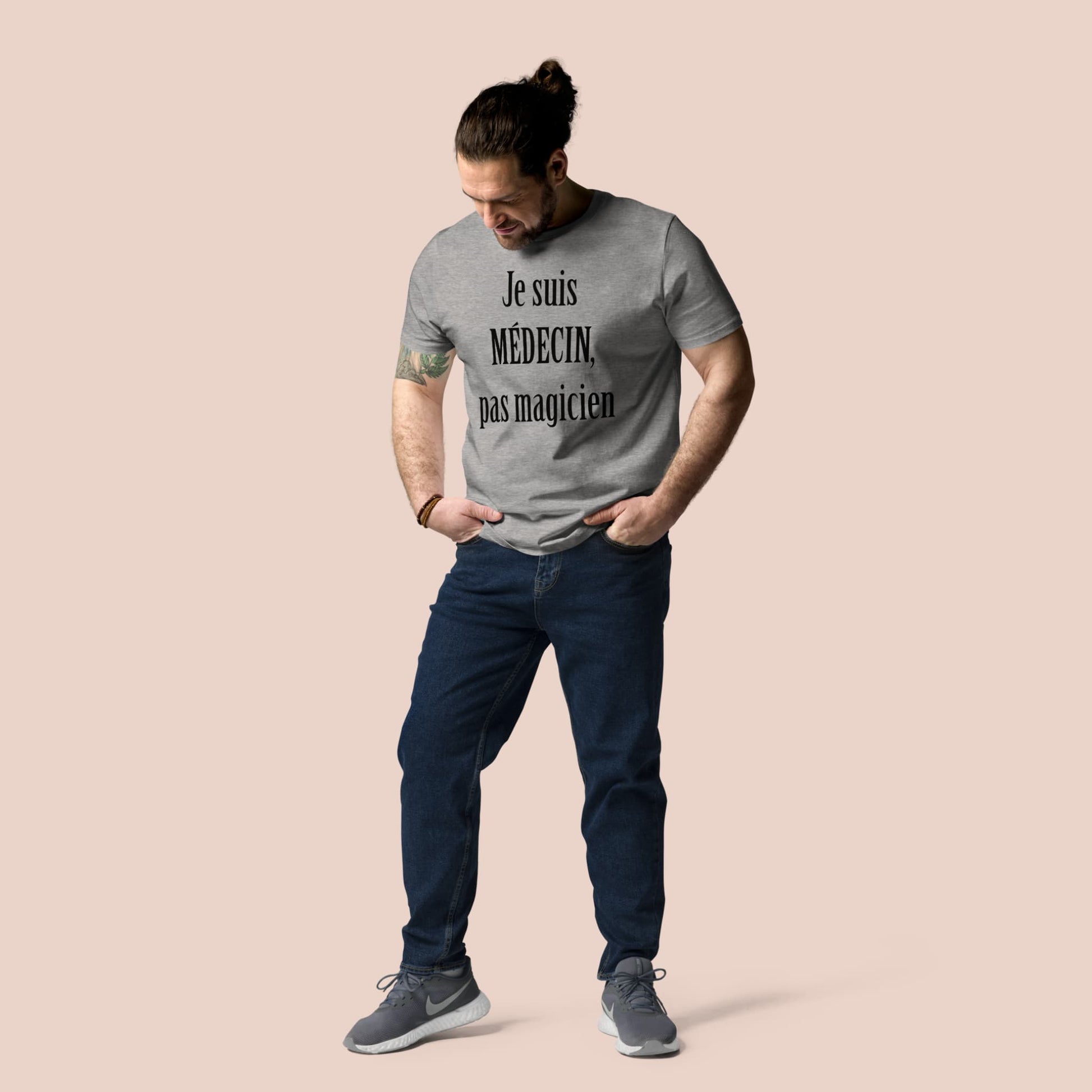 Homme portant un t-shirt gris chiné avec texte noir humoristique « Je suis médecin, pas magicien » – Artic60
