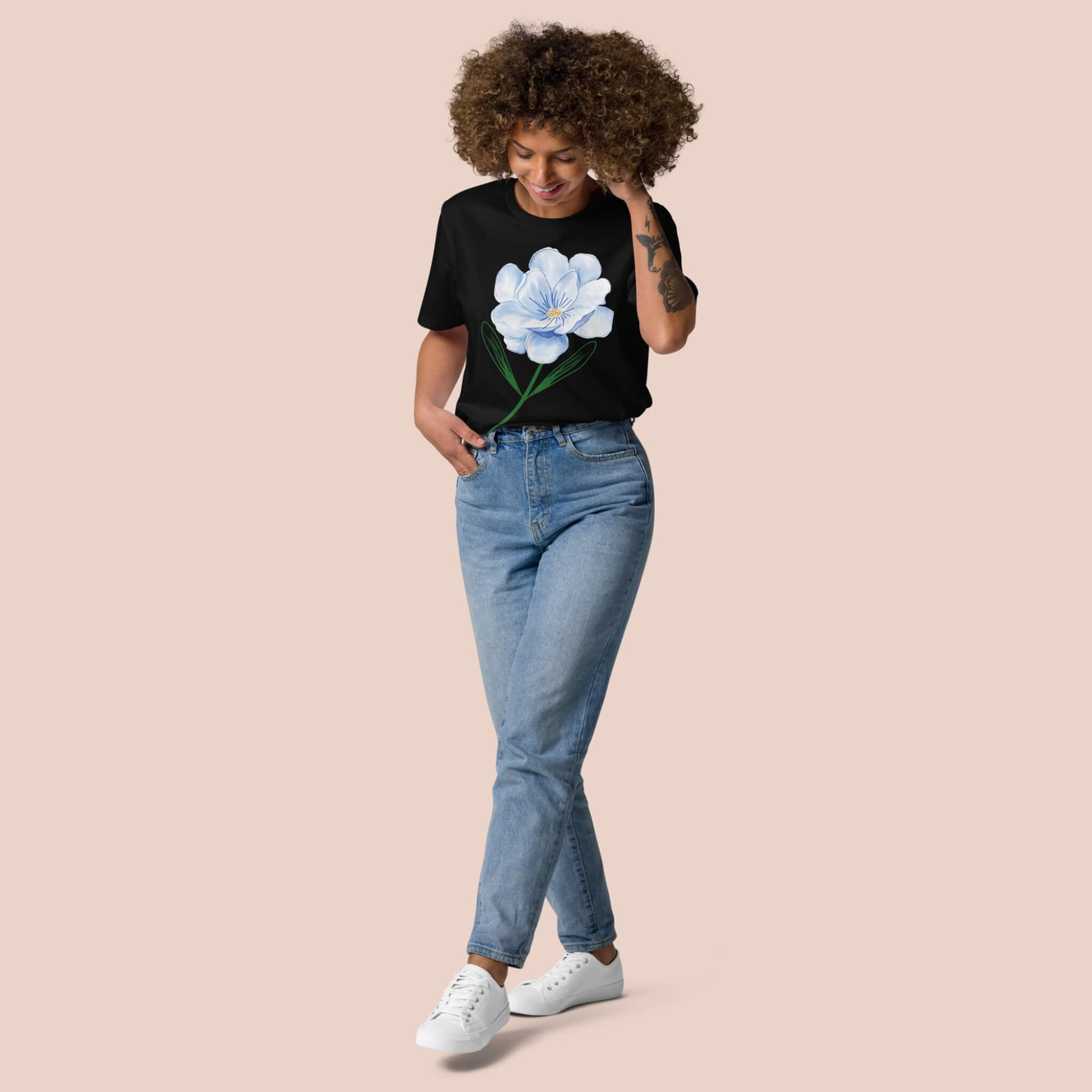 T-shirt noir en coton bio porté par une femme, avec une fleur bleue imprimée – Artic60