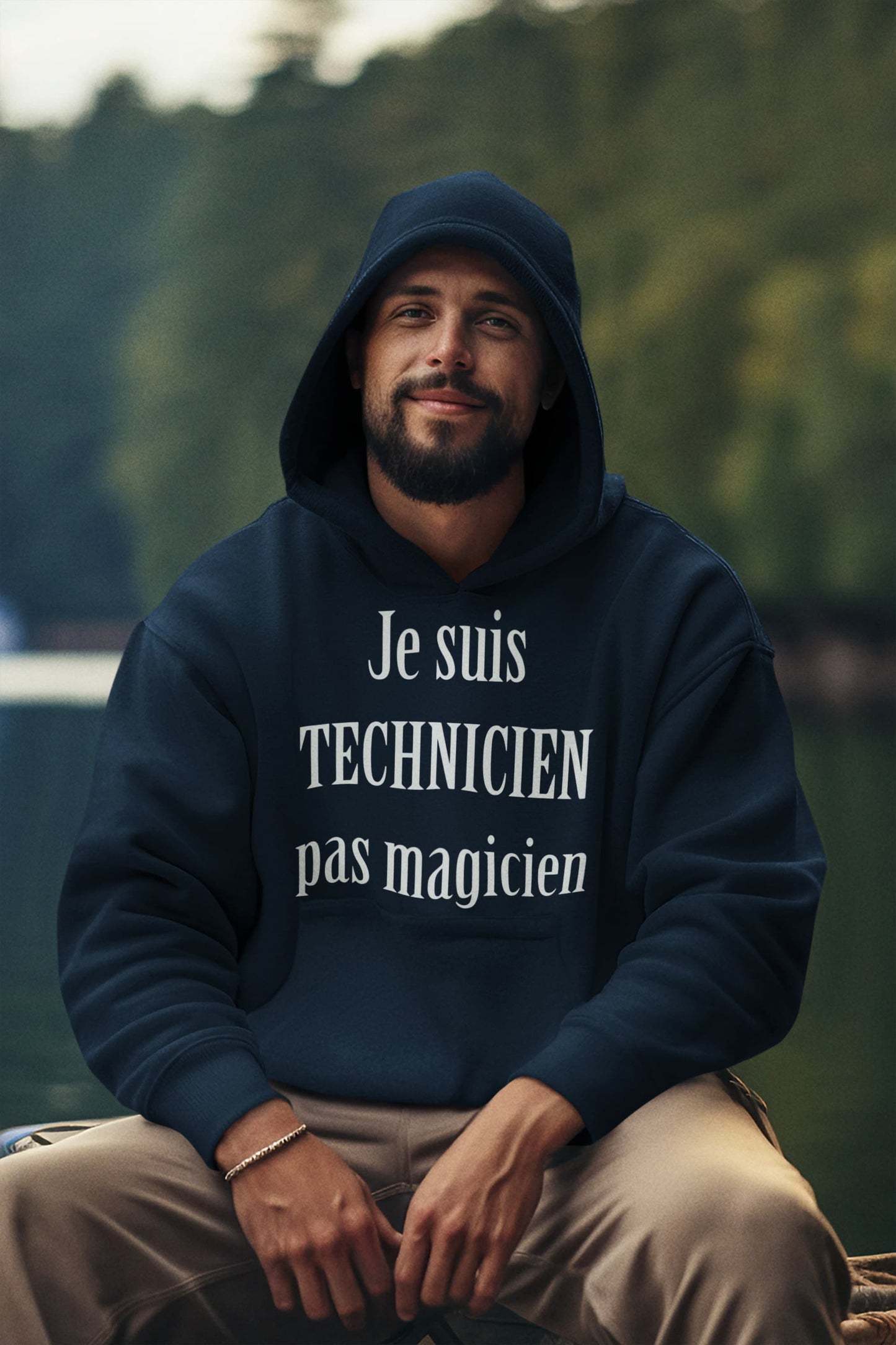 Homme souriant en extérieur portant un hoodie bleu marine "Je suis technicien, pas magicien" - Artic60