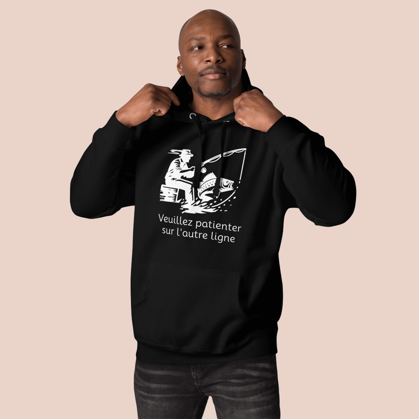Homme portant un hoodie noir avec motif pêcheur et texte « Veuillez patienter sur l'autre ligne » - Artic60