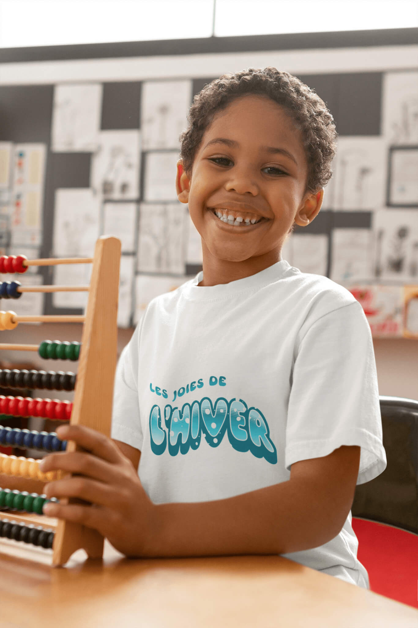 Garçon joyeux portant un t-shirt enfant blanc en coton bio avec le texte « Les joies de l'hiver » – Artic60