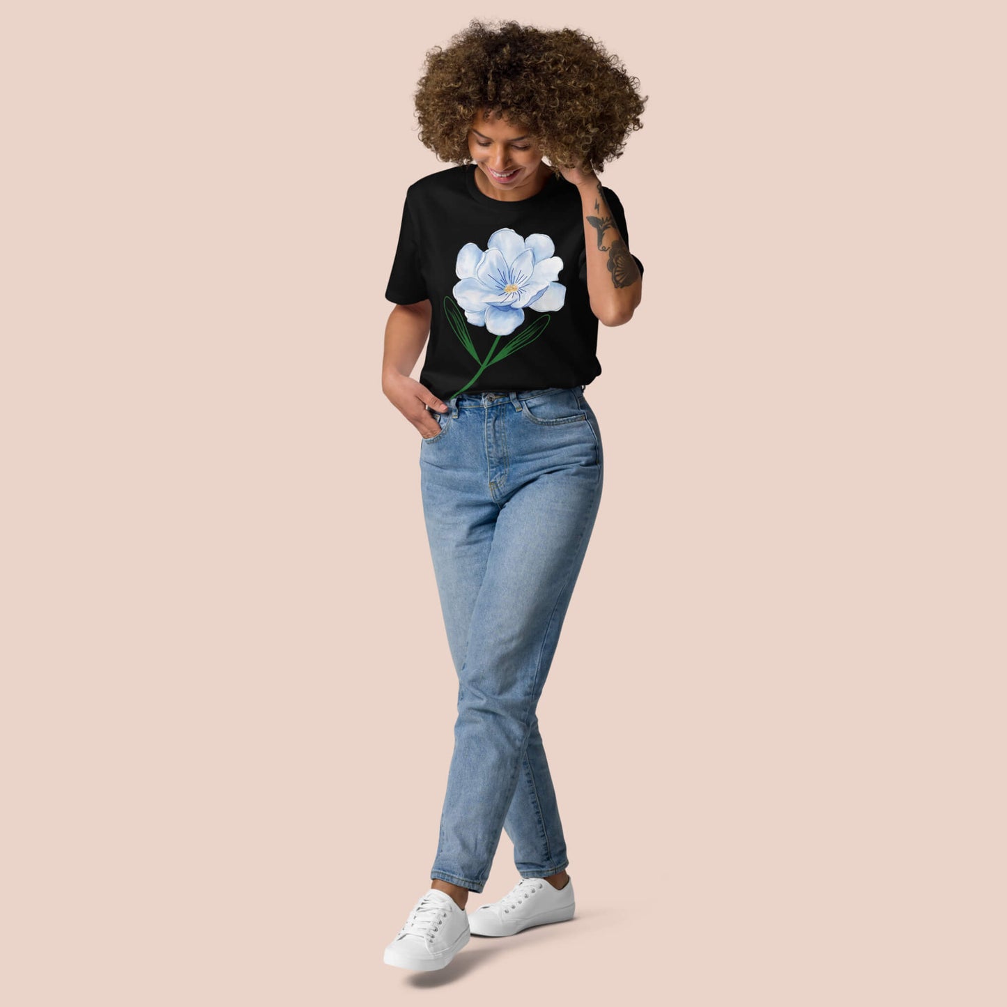 T-shirt noir en coton bio porté par une femme, avec une fleur bleue imprimée – Artic60